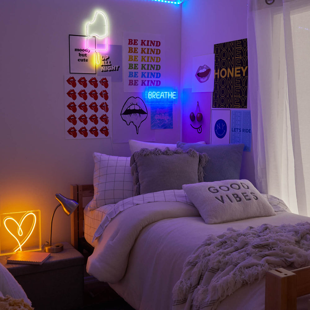 Room from Dormify decorated with neon signs in heart shape, popsicle shape, and a sign that says "breathe"